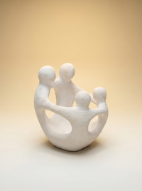 Zijaanzicht van het witte aardewerk familiebeeld Amity met vier omarmende figuren