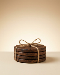 Stack of four round walnut wood coasters tied with jute twine