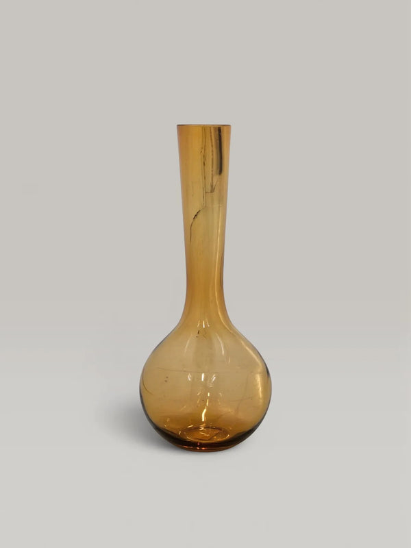 Laydhome Mombassa mouth-blown amber glass vase with a tall, sculptural neck and warm, translucent finish.