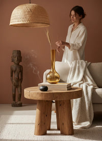 Laydhome mouth-blown amber glass vase on a wooden side table in a warm, bohemian-styled living room.